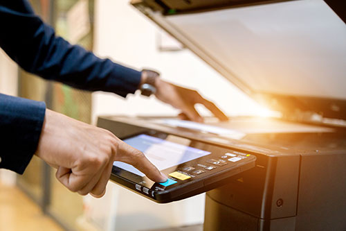 Person's hands using a photocopier